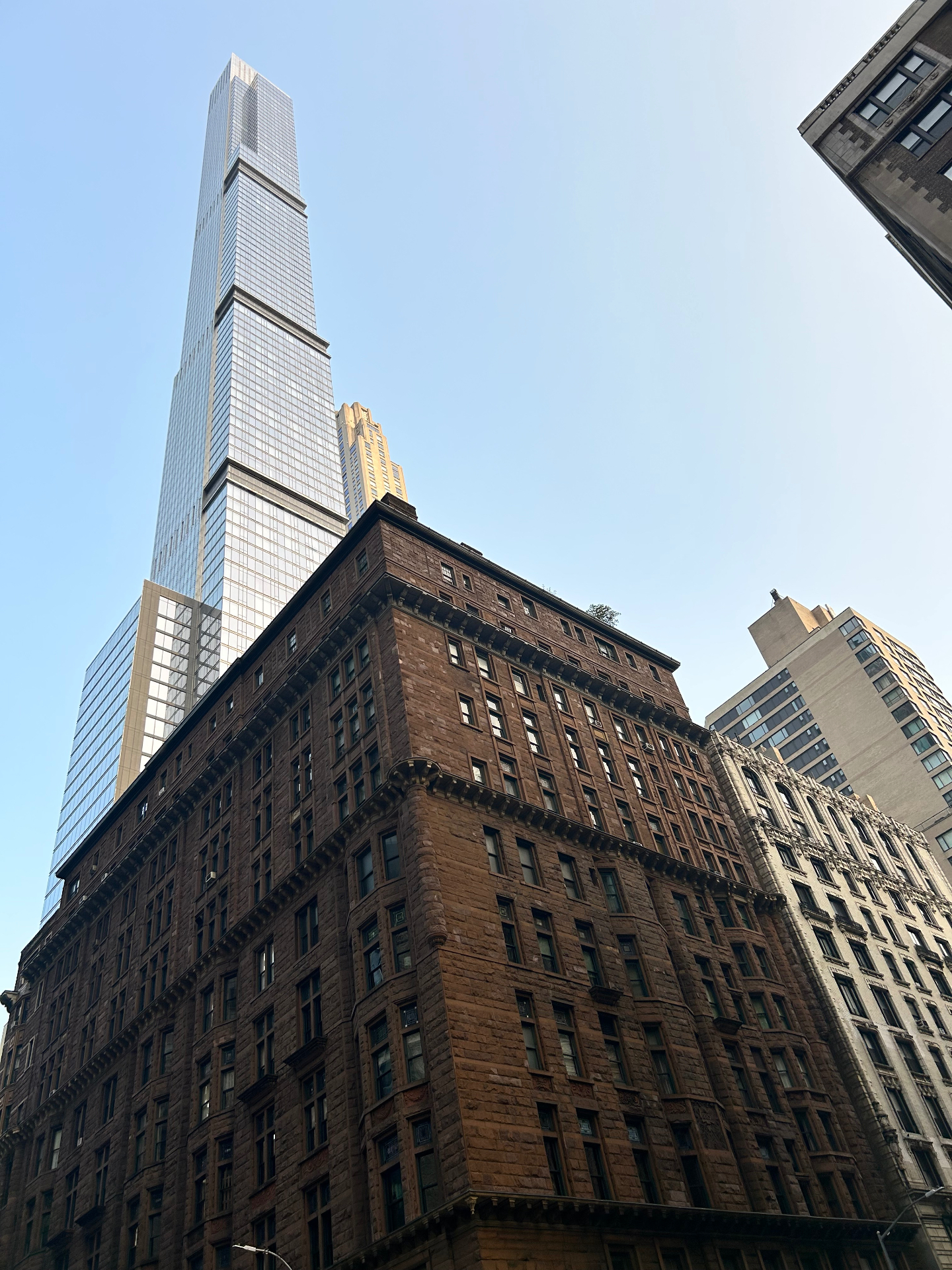Steinway Tower wznosząca się nad klasycznymi kamienicami - smukły superwysoki wieżowiec kontrastujący z zabytkową architekturą Midtown