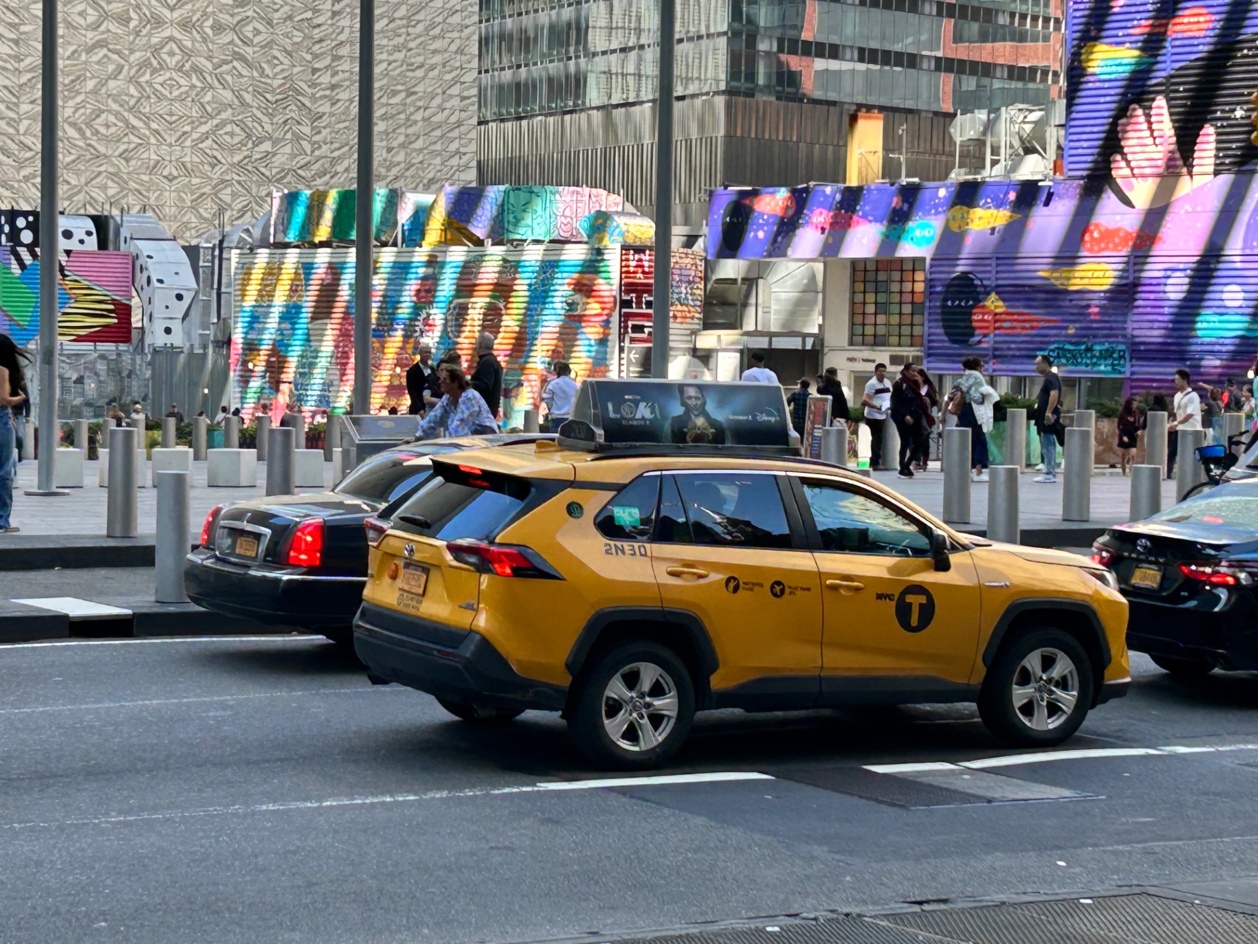 Żółta taksówka na Times Square - typowo nowojorska scena z kolorowymi billboardami